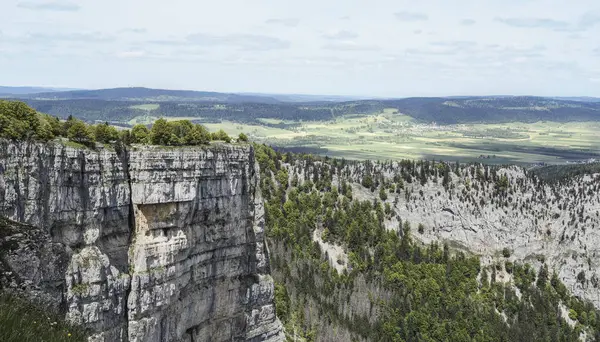 Creux du Van kireçtaşı oluşumu, İsviçre 'nin Jura Dağları' nda dramatik kaya duvarları, yemyeşil ormanlar ve aşağıdaki vadinin panoramik manzarası..