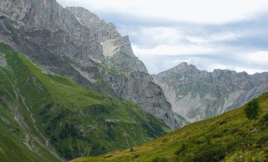 Çarpıcı dağ manzarası, yüksek tepeler ve canlı yeşil vadilerle doğal güzelliklerle dolu barışçıl bir dağ manzarasının özünü yakalıyor.