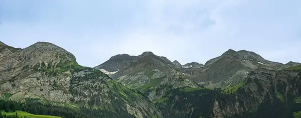 Sersemletici dağ manzarası, yüksek tepeler ve canlı yeşil vadiler içerir. Doğanın güzelliğinin ihtişamını vurgulayan barışçıl bir atmosfer yaratır.