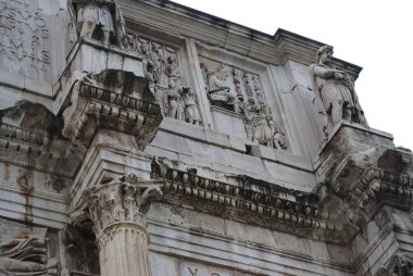 Antik Roma mimarisindeki karmaşık oyma ve heykellere yakından bakınca, klasik Roma inşaatının ihtişamını ve tarihsel önemini ayrıntılı taş oymalar ve sütunlarla gösteriyor..