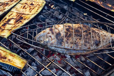 Baharatlı bir balık ve ızgara patlıcan ızgarası ızgara kömür üzerine ızgara kömür, ağız sulandırıcı detaylar ve kırsal bir his ile yakalanır..