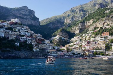 Positano 'nun nefes kesici manzarası, İtalya' nın Amalfi Sahili boyunca uzanan muhteşem bir uçurum kenarı köyü. Görüntü, renkli yamaçlardaki evleri ve yemyeşil yeşillikleri yakalıyor. Derin mavi Akdeniz 'e dökülüyor..
