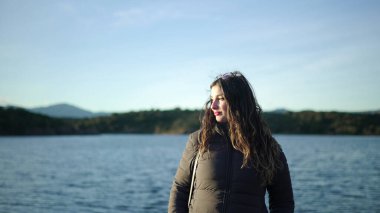 Güneşli bir günde nefes kesen göl manzarasının tadını çıkaran turistler, doğanın güzelliğinden ilham alıyorlar.