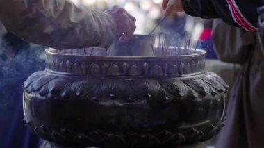 Tütsü yakan turistler Todai-ji Tapınağı, Nara, Japonya 'da büyük bir bronz tütsü ocağında tütsü yakarlar.