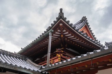 Sarı Duvarları ve Bulutlu Gökyüzü Arkaplanı olan Japon Tapınağının Siyah Çatı 'sı. Yüksek kalite fotoğraf 