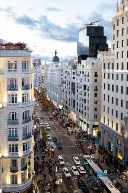 Gran Via at Sunset from Madrid Skyscraper with City Traffic and Illuminated Skyline. High quality photo clipart