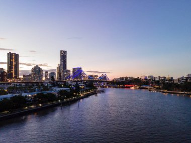 Brisbanes gökyüzü ve hikaye köprüsü alacakaranlıkta parlıyor, büyüleyici bir şehir manzarası yaratıyor