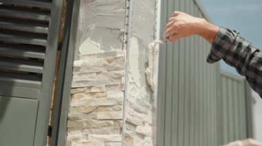 Konut yenileme projesi sırasında ustalık gerektiren mason tekniğini gösteren hassas mala ile dış duvar yüzeyinin profesyonel olarak düzleştirilmesi