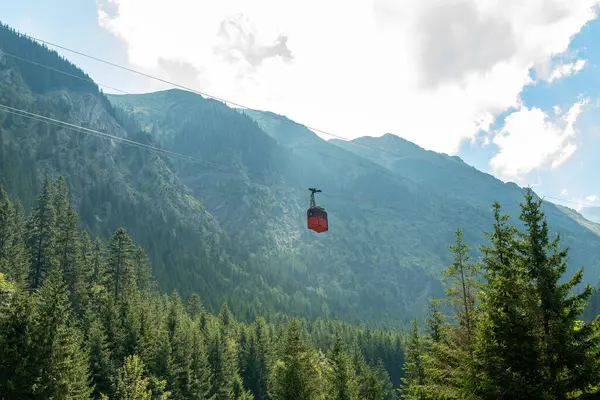 Romanya 'nın transfagarasyan bölgesindeki pitoresk bir dağ vadisinde turistleri taşıyan kırmızı teleferik Karpat dağlarının nefes kesici manzaralarını sunuyor.
