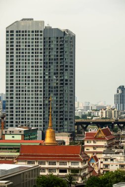 Bu resim, çağdaş kent mimarisine karşı birleşmiş tarihi bir tapınağı, hareketli bir şehir manzarasında gelenek ve modern yaşamın kesişimini sembolize ediyor..