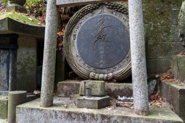 Kyoto, Japonya - 27 Aralık 2024: Gündüz vakti sakin bir orman ortamında karmaşık oymalar yapılmış tarihi taş anıt. Yüksek kalite fotoğraf