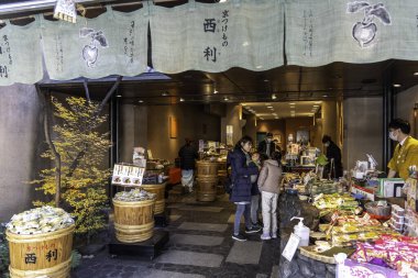 Kyoto, Japonya - 27 Aralık 2024: Kyoto pazarında yerel mutfak kültürünü ön plana çıkaran geleneksel Japon aperatifleri ve tatlılarının canlı gösterimi. Yüksek kalite fotoğraf
