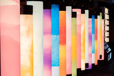 Günbatımında modern bir sergi alanında renkli desenler gösteren parlak sütunlar dizisi. Yüksek kalite fotoğraf