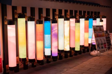 Günbatımında modern bir sergi alanında renkli desenler gösteren parlak sütunlar dizisi. Yüksek kalite fotoğraf