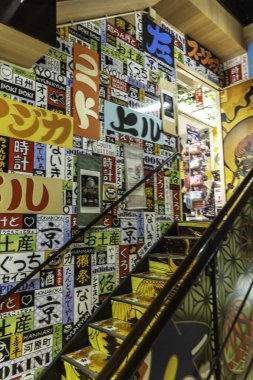 Kyoto, Japonya - 27 Aralık 2024: Canlı kentsel alanda kültürel ifadelerle dolu renkli işaretlerle süslenmiş canlı merdiven. Yüksek kalite fotoğraf