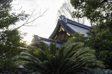Güneş ışığı ağaçların arasından Gion 'daki geleneksel bir Japon binasına süzülür ve dingin bir atmosfer yaratır. Yüksek kalite fotoğraf