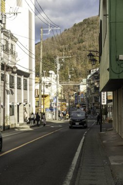 Fujiyama, Japonya - 2 Ocak 2025: Arka planda dağlarla birlikte kış güneşinde pitoresk bir Japon kasabasında dolambaçlı bir yol. Yüksek kalite fotoğraf