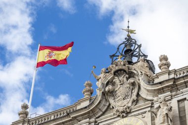 Canlı bir İspanyol bayrağı görkemli bir binanın tepesinde zarif bir şekilde dalgalanıyor. Bölgedeki ulusal gurur ve kültürel kimliği gözler önüne seriyor.