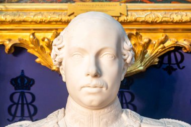 Kafasına zarif bir taç takmış bir adamı tasvir eden güzel bir heykel sanat ve beceri sergiliyor.