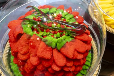 A delicious red and green cake adorned with colorful tongs placed right on top of it for a unique decorative touch