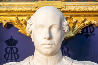 Kafasına zarif bir taç takmış bir adamı tasvir eden güzel bir heykel sanat ve beceri sergiliyor.