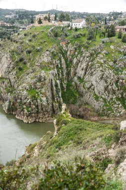 Huzurlu bir nehir, iki görkemli dağ arasında uzanan yemyeşil bir vadi boyunca zarafetle kıvrılır.