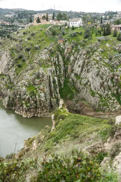 Huzurlu bir nehir, iki görkemli dağ arasında uzanan yemyeşil bir vadi boyunca zarafetle kıvrılır.