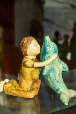 Meksika 'da sanatı kucaklayan bir çocuk ve yunus figürü, yerel bir zanaatkar pazarında bağlantı ve yaratıcılığın ruhunu yakalıyor. Yüksek kalite fotoğraf