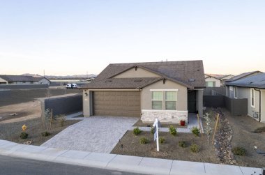 Bu, ağaçlar ve diğer evlerle çevrili güzel gelişmiş bir yerleşim bölgesinde bulunan bir evi gösteren hava görüntüsü.