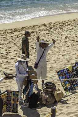 Cabo San Lucas - 2 Şubat 2024: canlı sahil satıcıları sakin bir Meksika kıyısı boyunca renkli el sanatları sergiliyorlar. Yüksek kalite fotoğraf