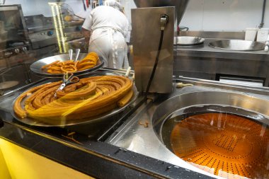 Lezzetli churro 'lar şu anda bir fırında pişiriliyor. Dolu bir mutfakta. Havayı baştan çıkaran bir koku yaratıyor.
