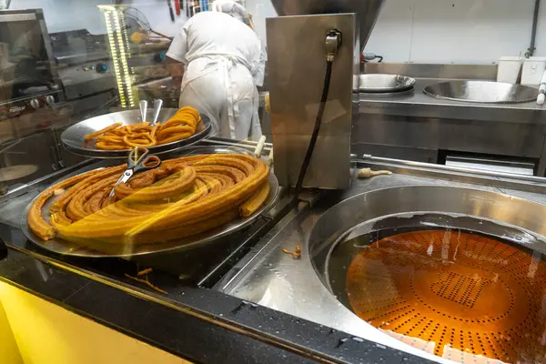 Lezzetli churro 'lar şu anda bir fırında pişiriliyor. Dolu bir mutfakta. Havayı baştan çıkaran bir koku yaratıyor.