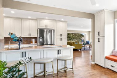 Zarif beyaz dolaplar ve parlak paslanmaz çelik aletlerle donatılmış modern bir mutfak şık ve işlevsel bir mutfak alanı yaratıyor.