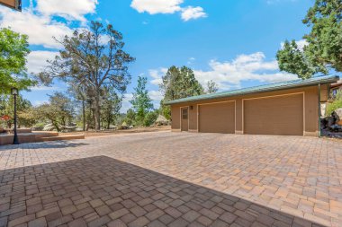 Düzgün döşenmiş tuğladan bir garaj yolu. İki farklı garaj kapısı olan bir garaja açılıyor. Özelliklerin kaldırımını güçlendiriyor.