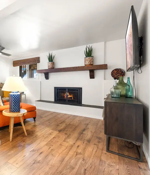 Eğlence ve rahatlama için düz ekran televizyonun yanında sıcak bir şömine bulunan rahat bir oturma odası.