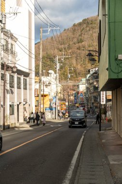 Fujiyama, Japonya - 2 Ocak 2025: Arka planda dağlarla birlikte kış güneşinde pitoresk bir Japon kasabasında dolambaçlı bir yol. Yüksek kalite fotoğraf