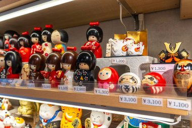 Kyoto, Japonya - 27 Aralık 2024: Bir zanaat atölyesinde raflarda sergilenen geleneksel Japon oyuncak bebek ve heykelciklerinin eşsiz koleksiyonu. Yüksek kalite fotoğraf