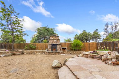 Büyüleyici taş bir şöminesi olan ve sağlam ahşap bir çitle çevrili güzel bir arka bahçesi var. Çok hoş bir ortam yaratıyor.