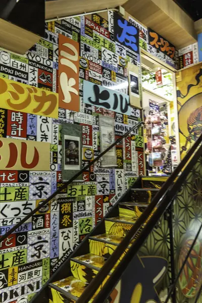 Kyoto, Japonya - 27 Aralık 2024: Canlı kentsel alanda kültürel ifadelerle dolu renkli işaretlerle süslenmiş canlı merdiven. Yüksek kalite fotoğraf