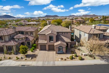 Başka evler ve yeşilliklerle çevrili bir yerleşim alanı içinde büyük ve etkileyici bir evi gösteren hava manzarası.