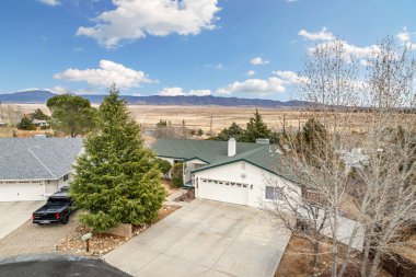 Bu görüntü büyüleyici arka plan manzarasında, yüksek dağların arasında yuva yapmış büyüleyici bir evin havadan görüntüsünü yakalıyor.