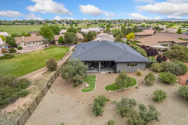 Bu resim, bereketli ağaçlar ve canlı otlar tarafından kucaklanan huzurlu bir yerleşim alanına yerleştirilmiş resimli bir evin havadan görüntüsünü sergiliyor.