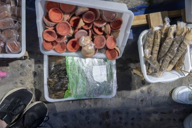 Bir insan, farklı türde yiyeceklerle dolu çeşitli konteynırlara sahip bir masanın tam önünde duruyor.