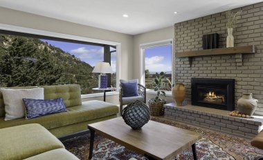 Hoş bir şöminesi, rahat bir koltuğu, şık bir masası ve birlikte düzenlenmiş davetkar sandalyeleri olan rahat bir oturma odası.