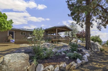 Büyüleyici bir ev, manzarayı güzelleştiren güzel tasarlanmış bir kaya bahçesinin hemen yanında, pitoresk bir tepenin üzerine kurulmuştur.