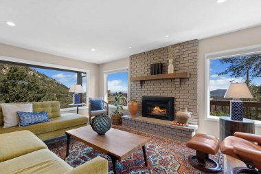 Eğlence ve rahatlama için düz ekran televizyonun yanında sıcak bir şömine bulunan rahat bir oturma odası.