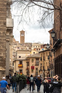 Farklı bireylerden oluşan bir grup hayat dolu kalabalık bir şehir olan dar bir caddede rahatça yürüyor.