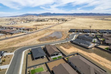 Bu görüntü, ağaçlarla çevrili çeşitli evleri gösteren ilginç ve büyüleyici bir hava manzarası sunuyor.