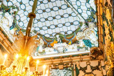 Nefis bir el yapımı avize, göz kamaştırıcı camdan tavanı olan geniş bir odanın tavanında zarif bir şekilde asılı duruyor.