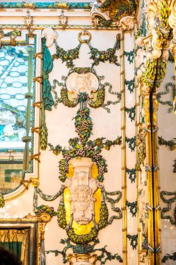 Bu resim, üzerine çok güzel dikilmiş bir heykeli belirgin bir şekilde gösteren bir duvarın detaylı bir yakın görüntüsünü içeriyor.